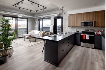 A modern kitchen with a large island and a dining area.